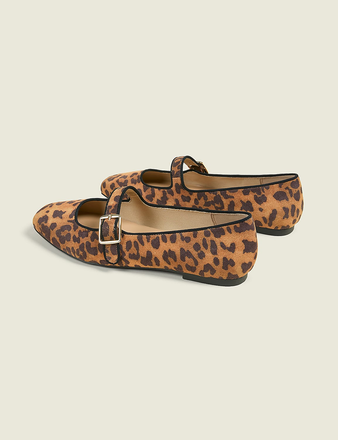 A pair of leopard-print Mary Jane flats with gold buckles are positioned on a plain, light beige background. Product Image 2