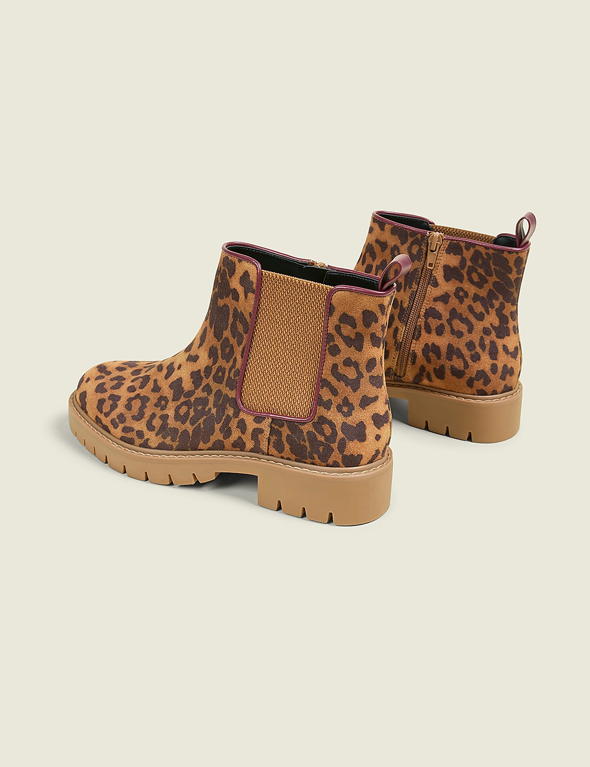 A pair of leopard-print Chelsea boots with tan soles are displayed against a plain, light-colored background. Product Image 2