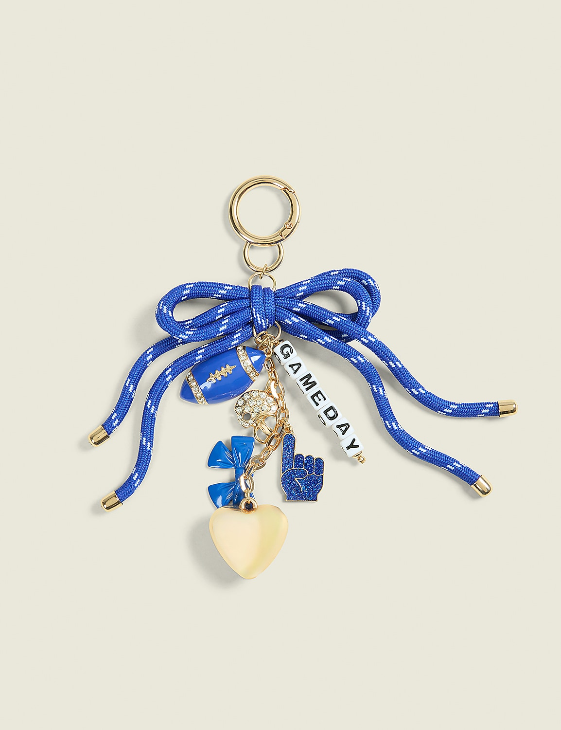 A blue ribbon bow with football-themed charms hangs from a gold keyring against a pale yellow background. Product Image 1