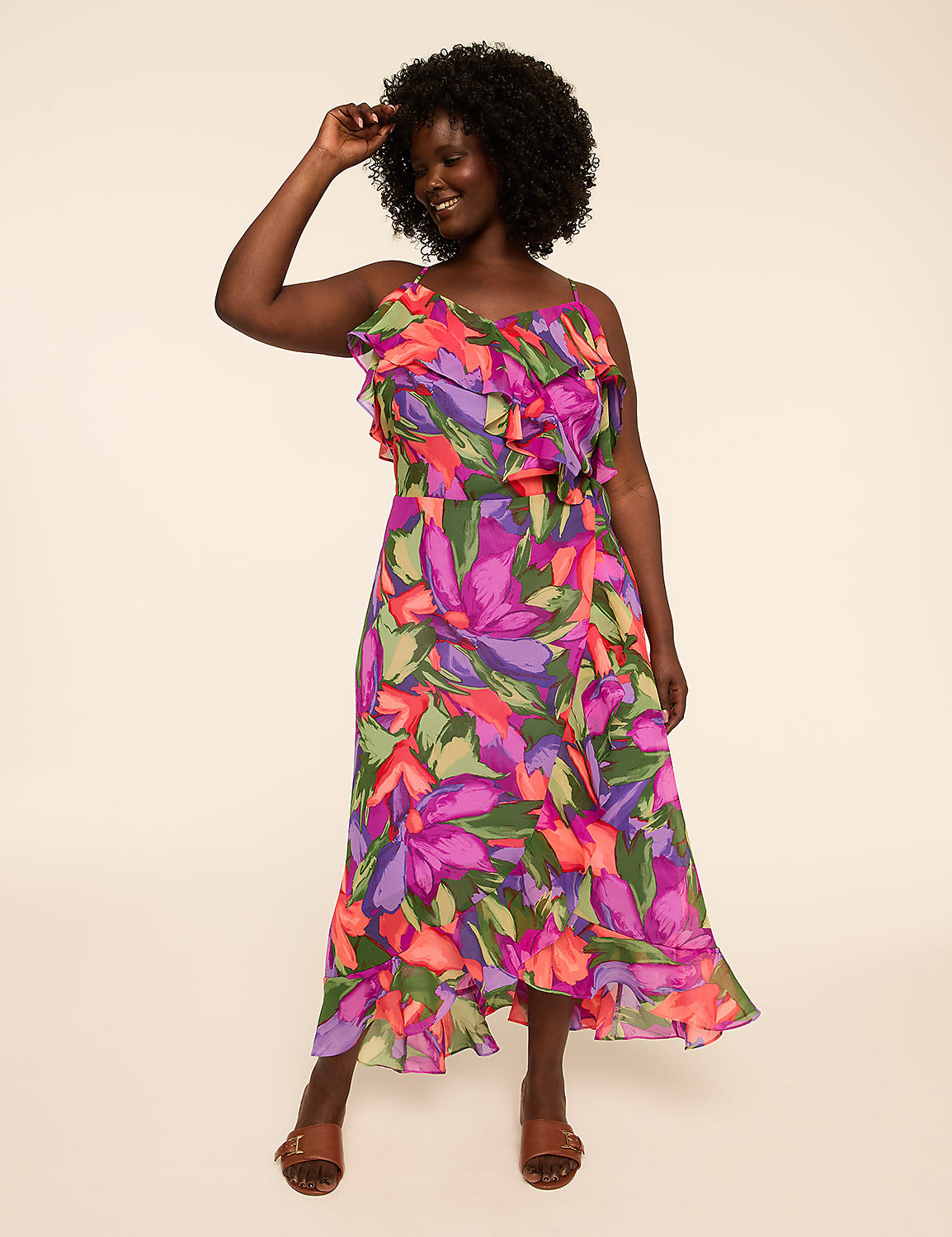 A woman in a vibrant floral dress stands against a plain, light-colored background. Product Image 4