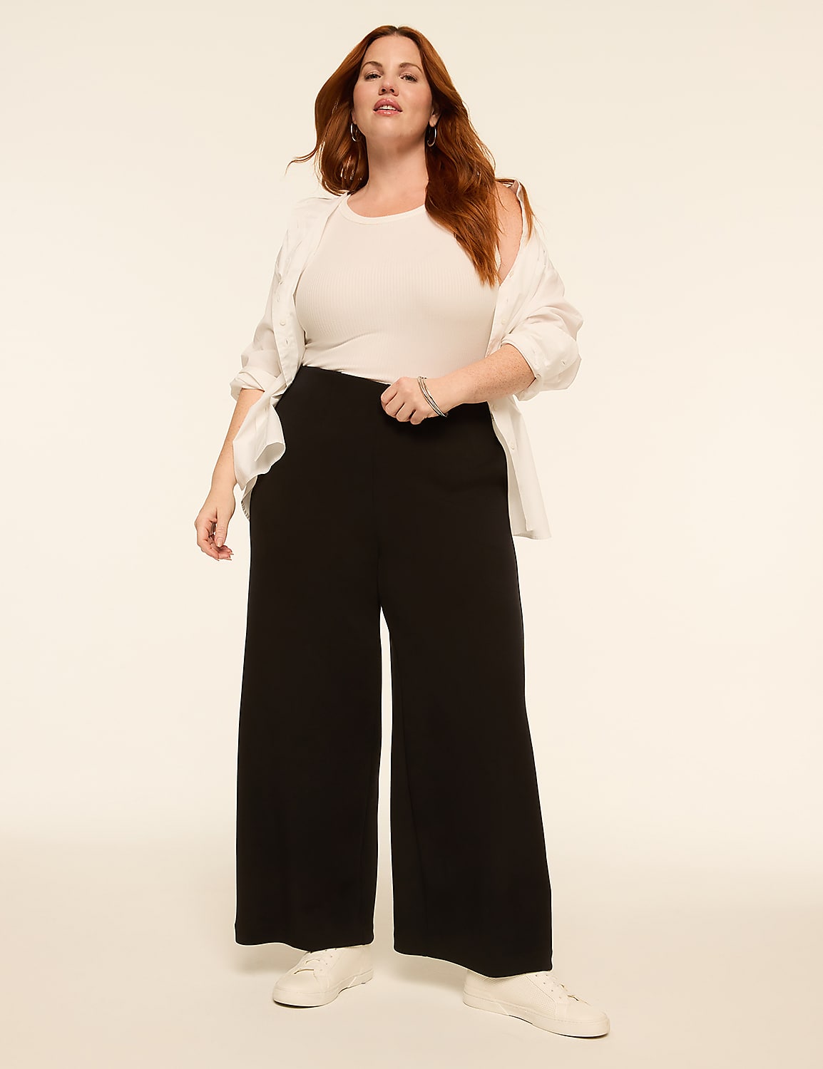A woman in a white top and black pants stands against a plain, light-colored background. Product Image 3