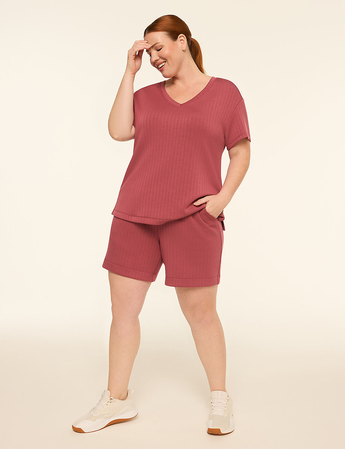A smiling woman in a rust-colored ribbed pajama set stands against a plain cream background. Product Image 3