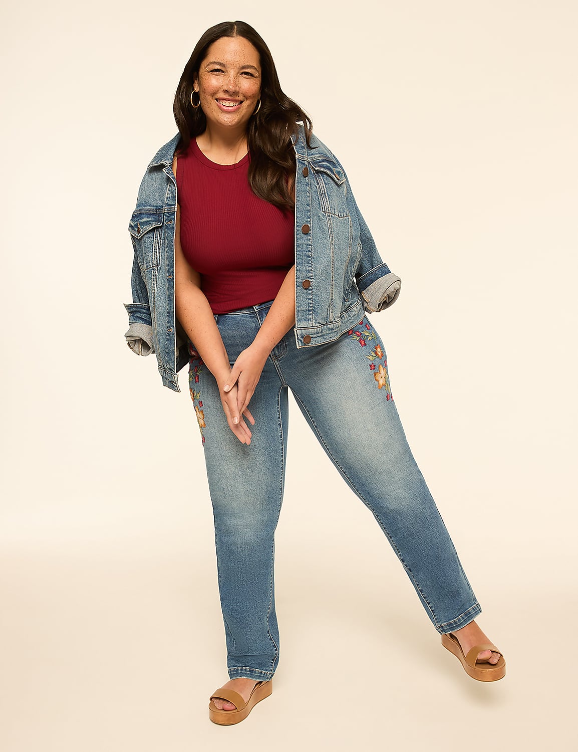 A smiling woman in a denim jacket and embroidered jeans stands against a plain, light-colored background. Product Image 3