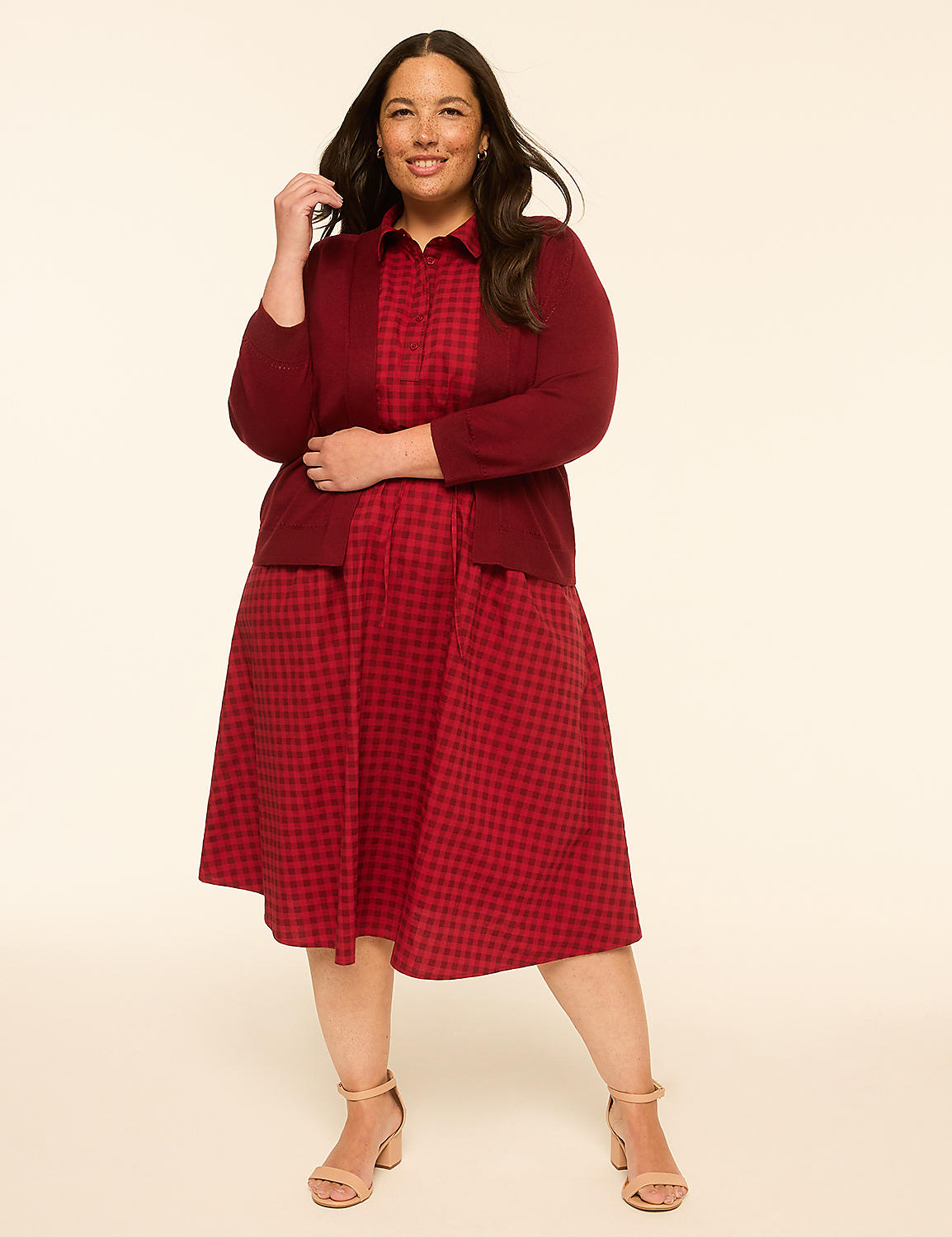 A smiling woman in a red gingham dress and cardigan stands against a plain, light-colored background. Product Image 3