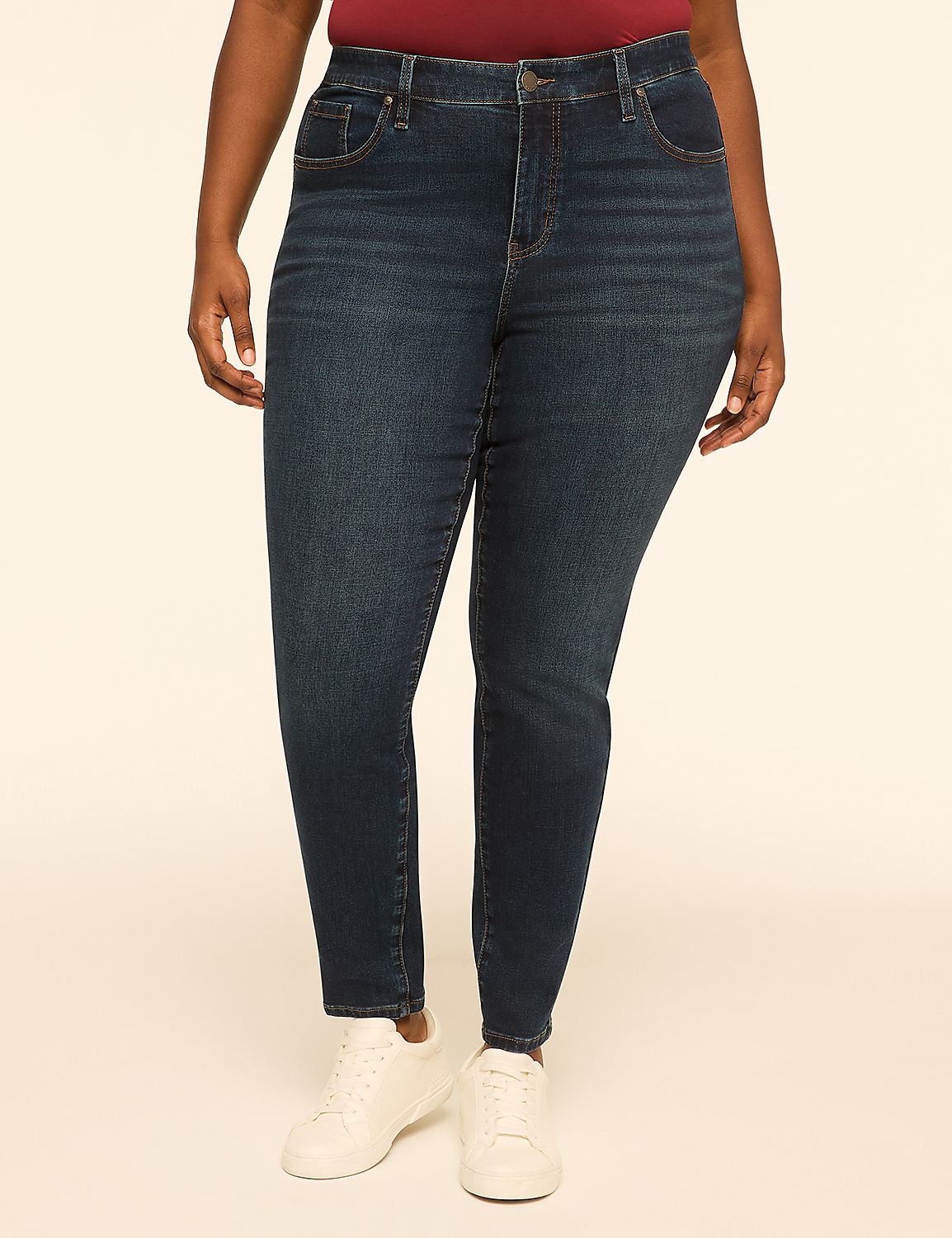 A person stands in dark wash skinny jeans and white sneakers against a plain, light-colored background. Product Image 1