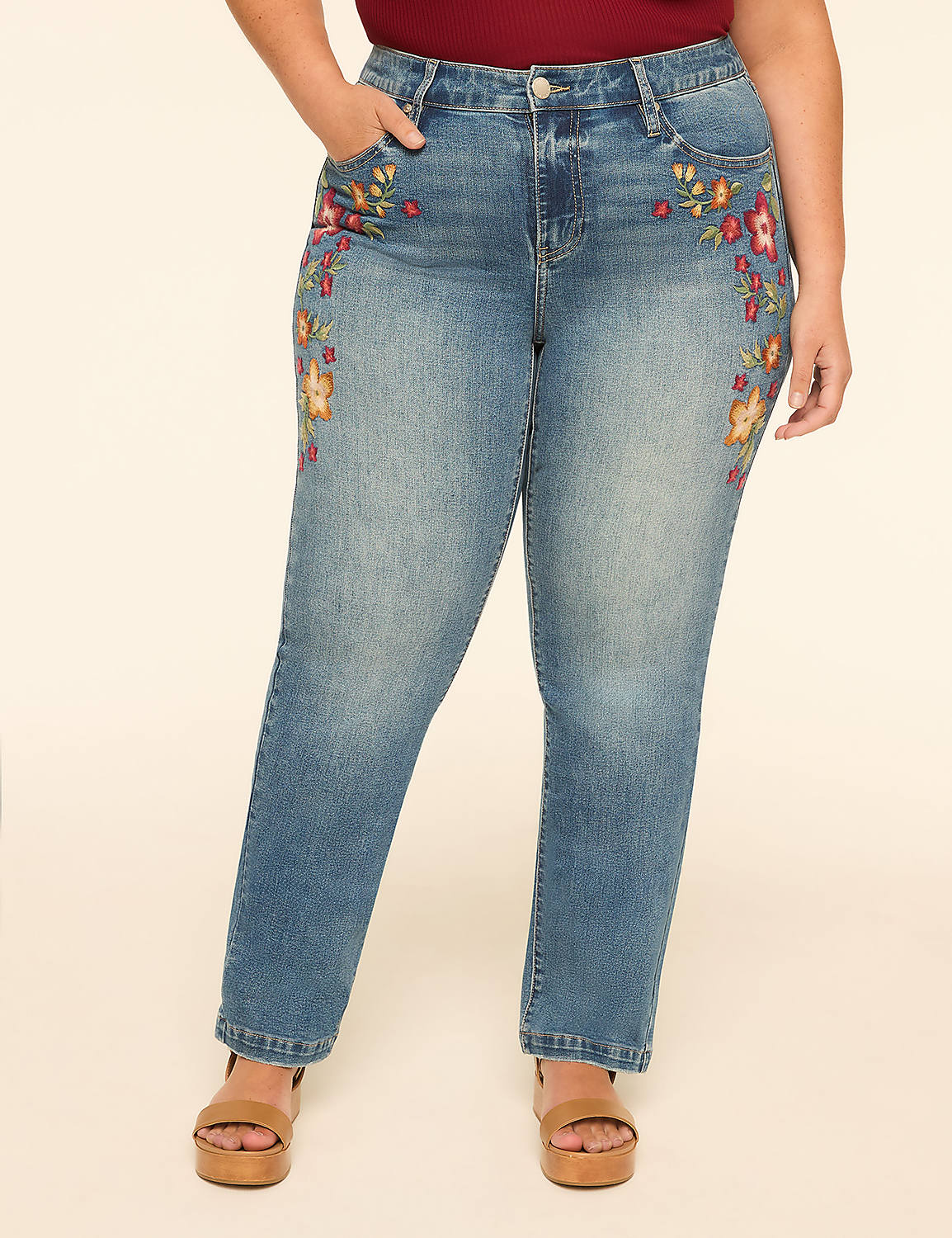 A woman in embroidered jeans stands against a plain, light-colored background. Product Image 1