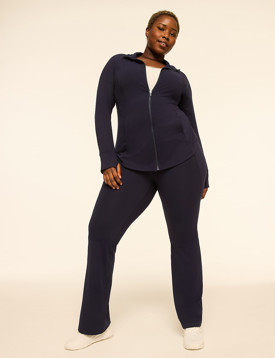 A woman in a navy blue tracksuit stands against a plain, light-colored background. Product Image 3