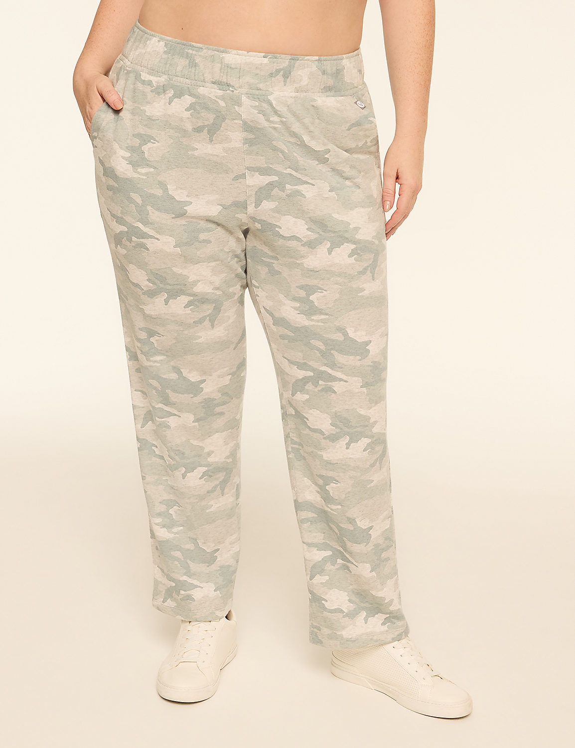 A person stands in camouflage pants and white sneakers against a plain, light-colored background. Product Image 1