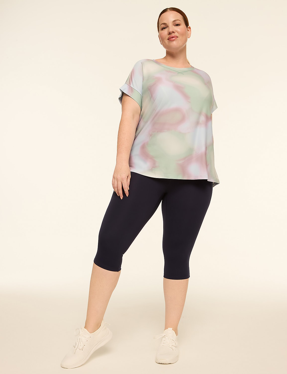 A woman in a tie-dye top and navy capris stands against a plain, light background. Product Image 3
