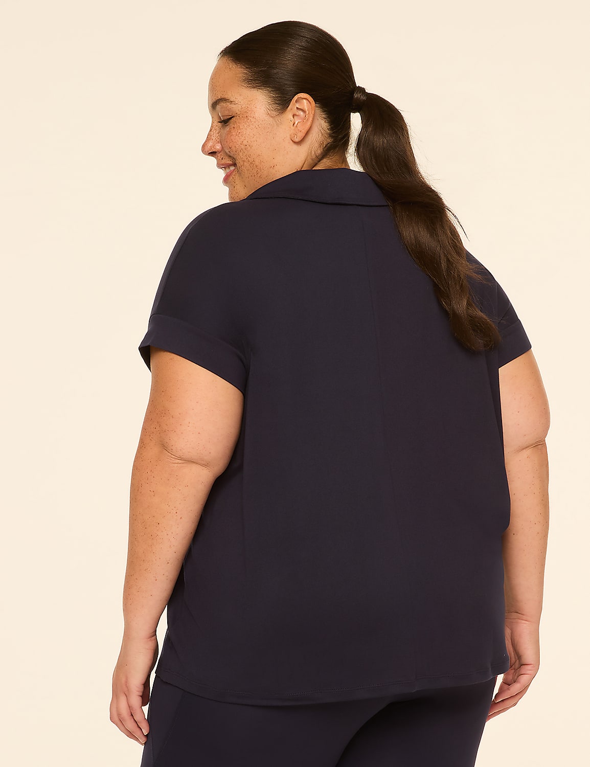 A woman in a navy blue shirt and pants stands against a plain cream background. Product Image 2