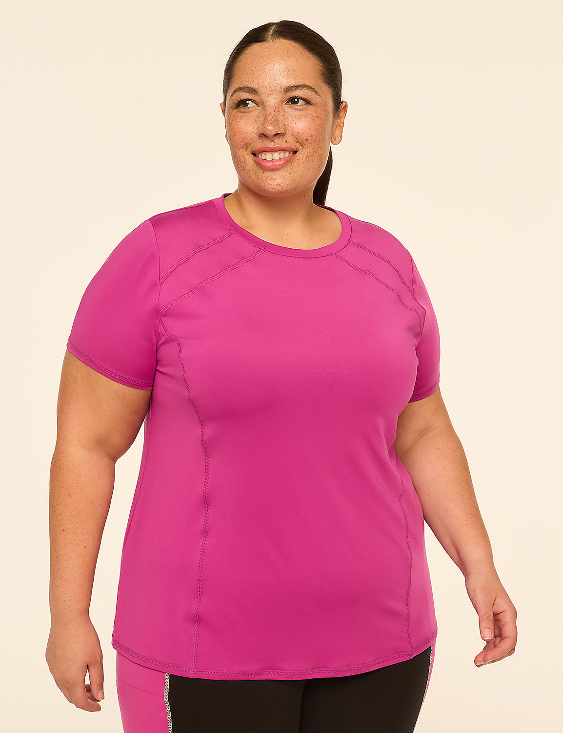 A smiling woman in a bright pink t-shirt stands against a plain, light-colored background. Product Image 1
