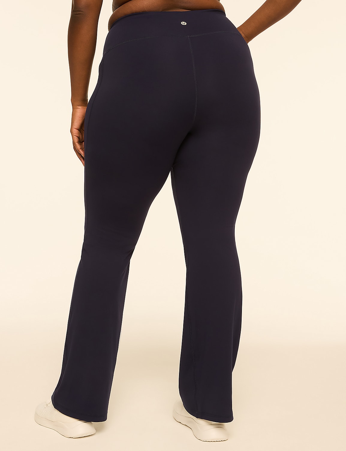 A person wearing navy flare leggings and white sneakers stands against a plain, light-colored background. Product Image 2