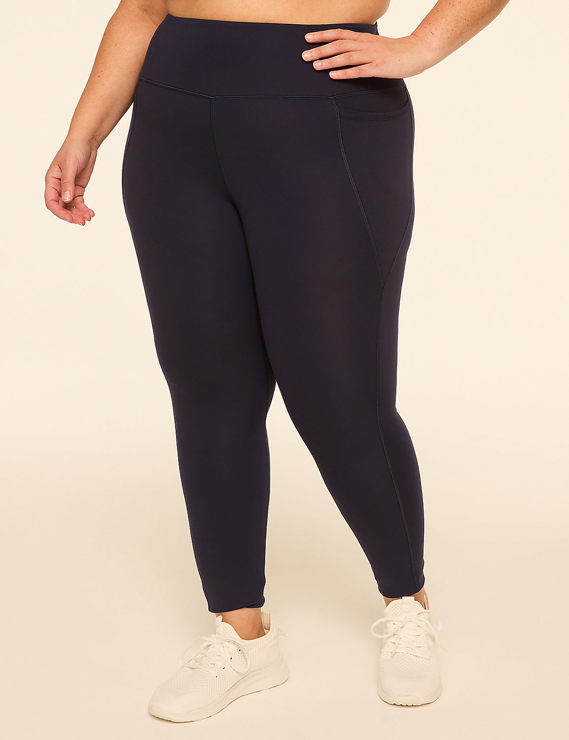 A person wearing navy leggings and white sneakers stands against a plain, light-colored background. Product Image 1