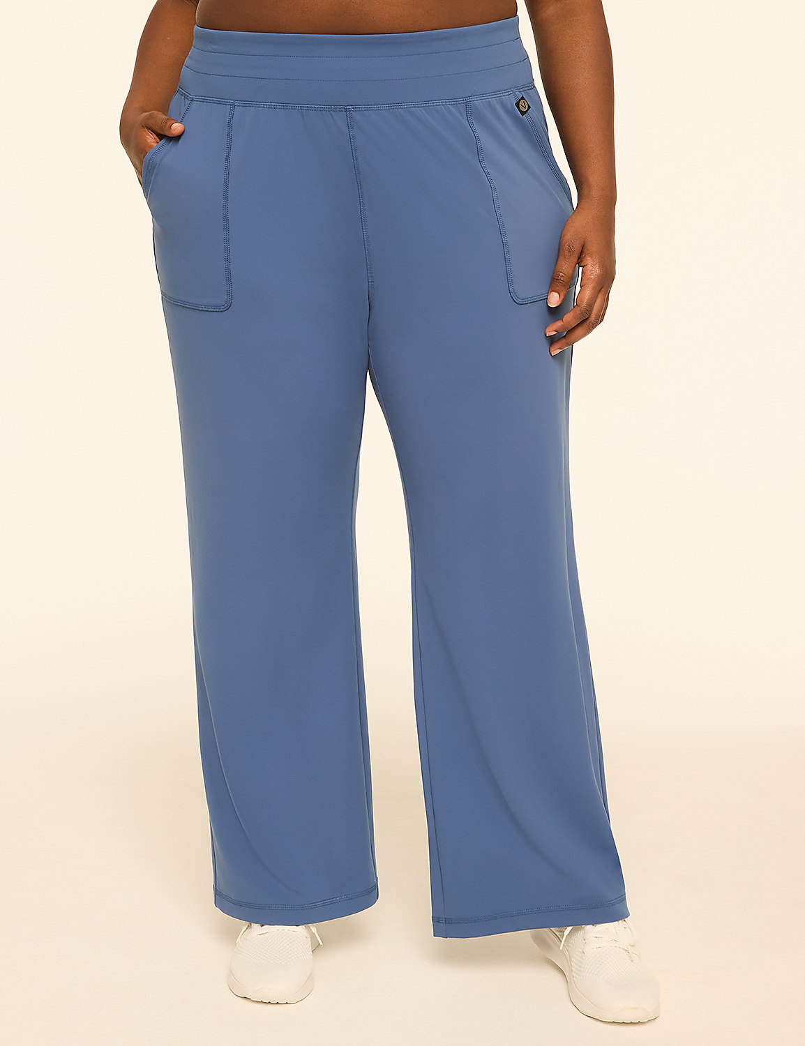 A person wearing blue wide-leg pants with pockets and white sneakers stands against a plain, light-colored background. Product Image 1