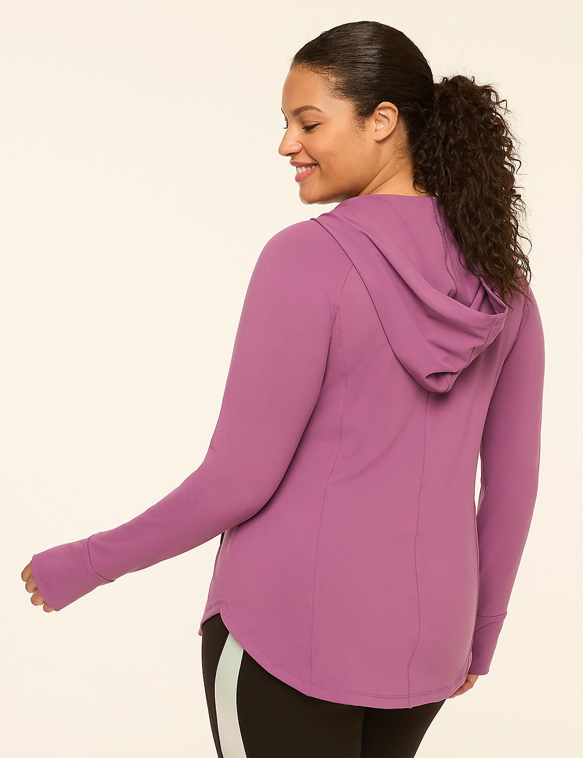 A woman in a purple hooded jacket with thumbholes stands against a plain, light-colored background. Product Image 2