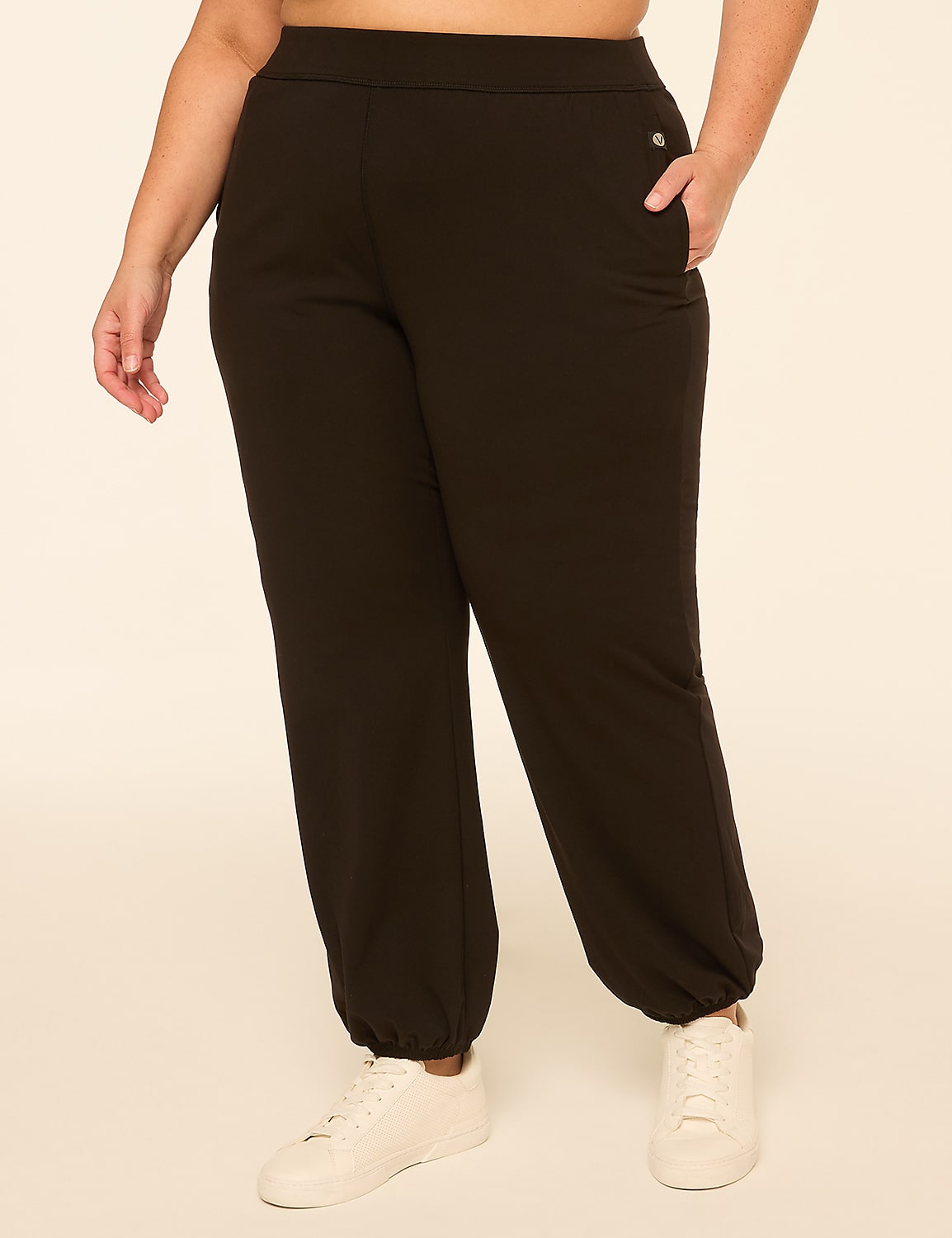 A person in black joggers and white sneakers stands against a plain, light-colored background. Product Image 1