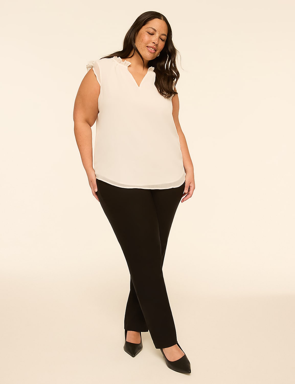 A woman in a white blouse and black pants stands against a plain, light-colored background. Product Image 3