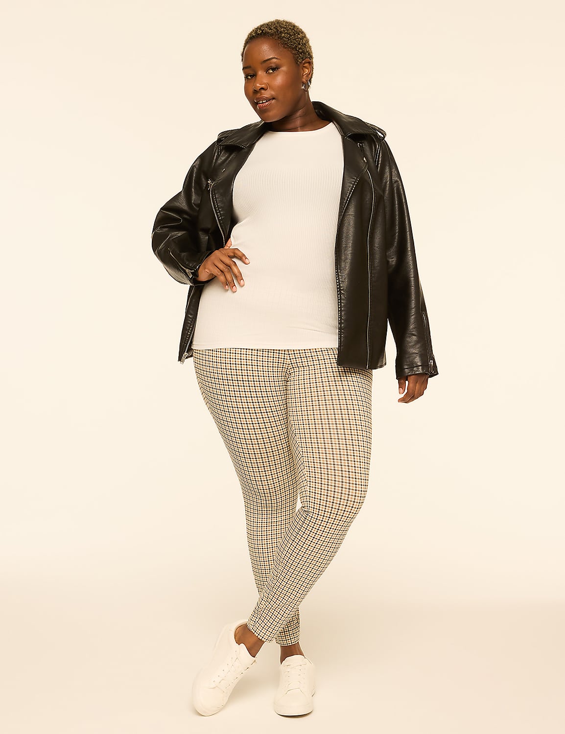 A woman in a white top, black leather jacket, and patterned leggings stands with her hand on her hip against a plain, light-colored background. Product Image 3