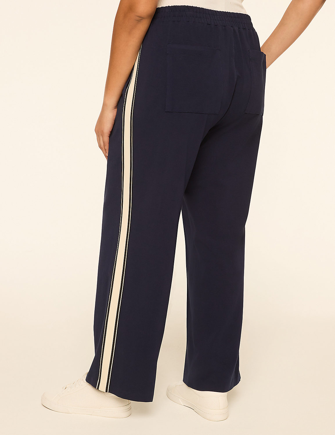 A person wearing navy blue pants with a white stripe down the side stands against a plain, light-colored background. Product Image 2