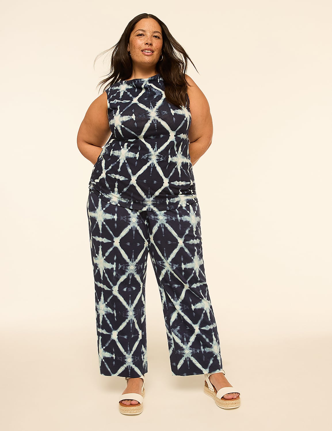A woman in a tie-dye jumpsuit stands against a plain, light-colored background. Product Image 3