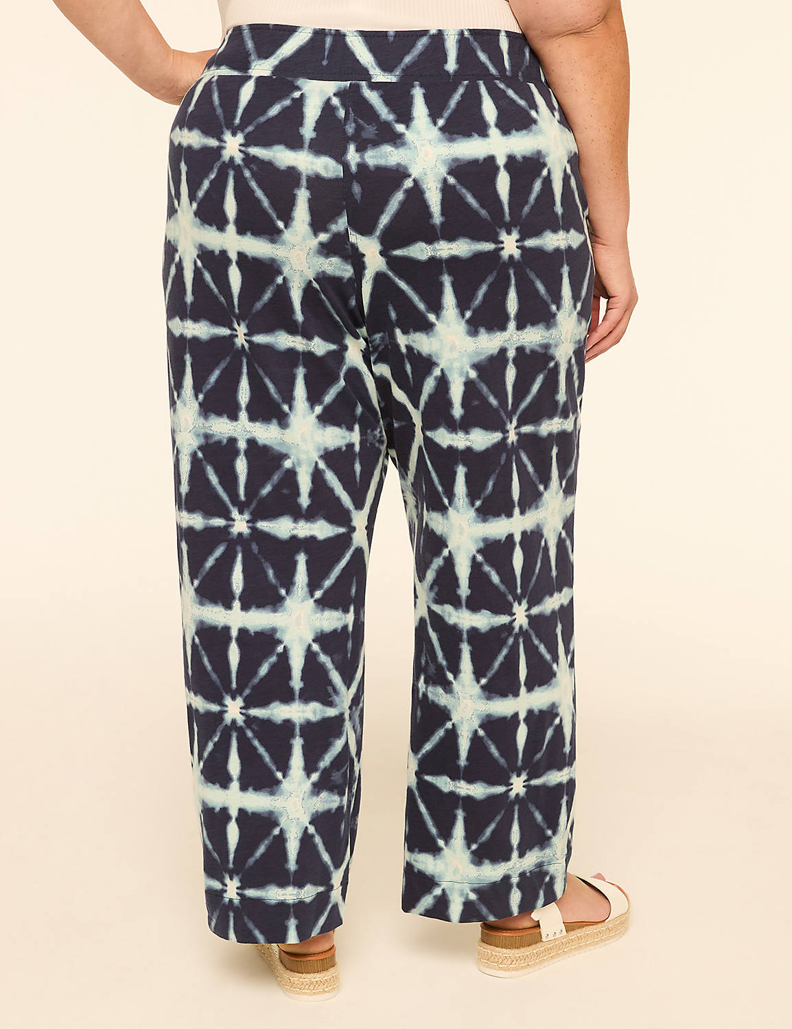 A person wearing patterned pants stands against a plain, light-colored background. Product Image 2