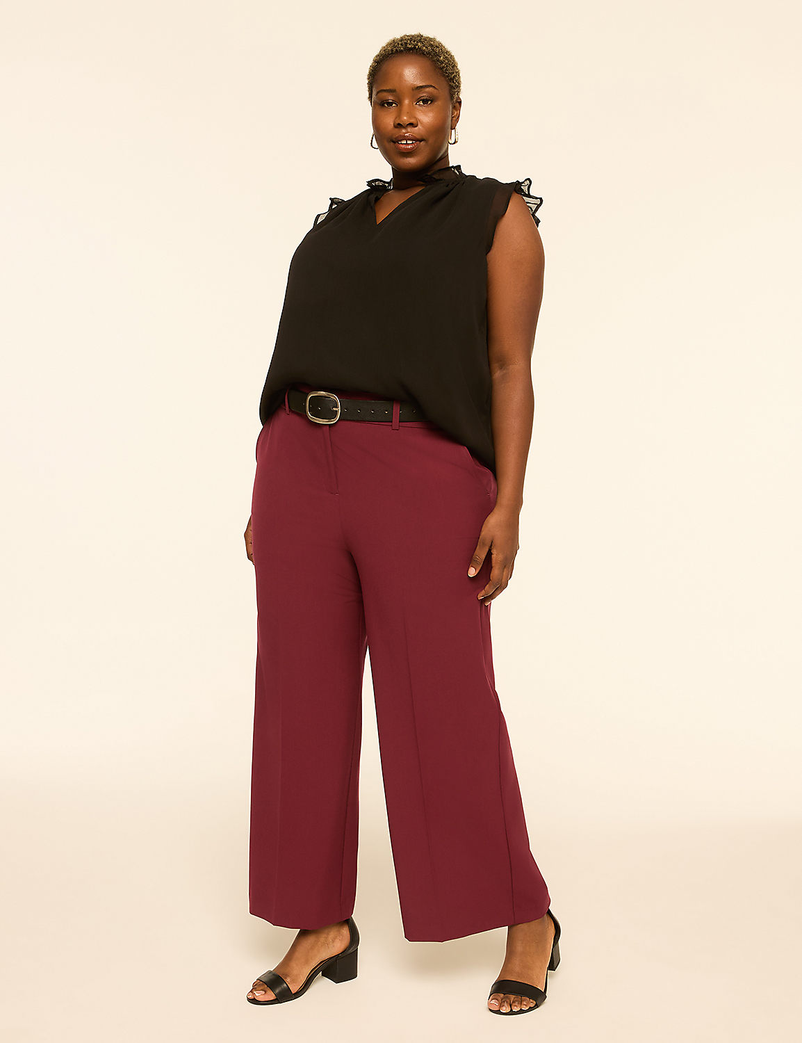 A woman in a black top and maroon pants stands against a plain, light-colored background. Product Image 3