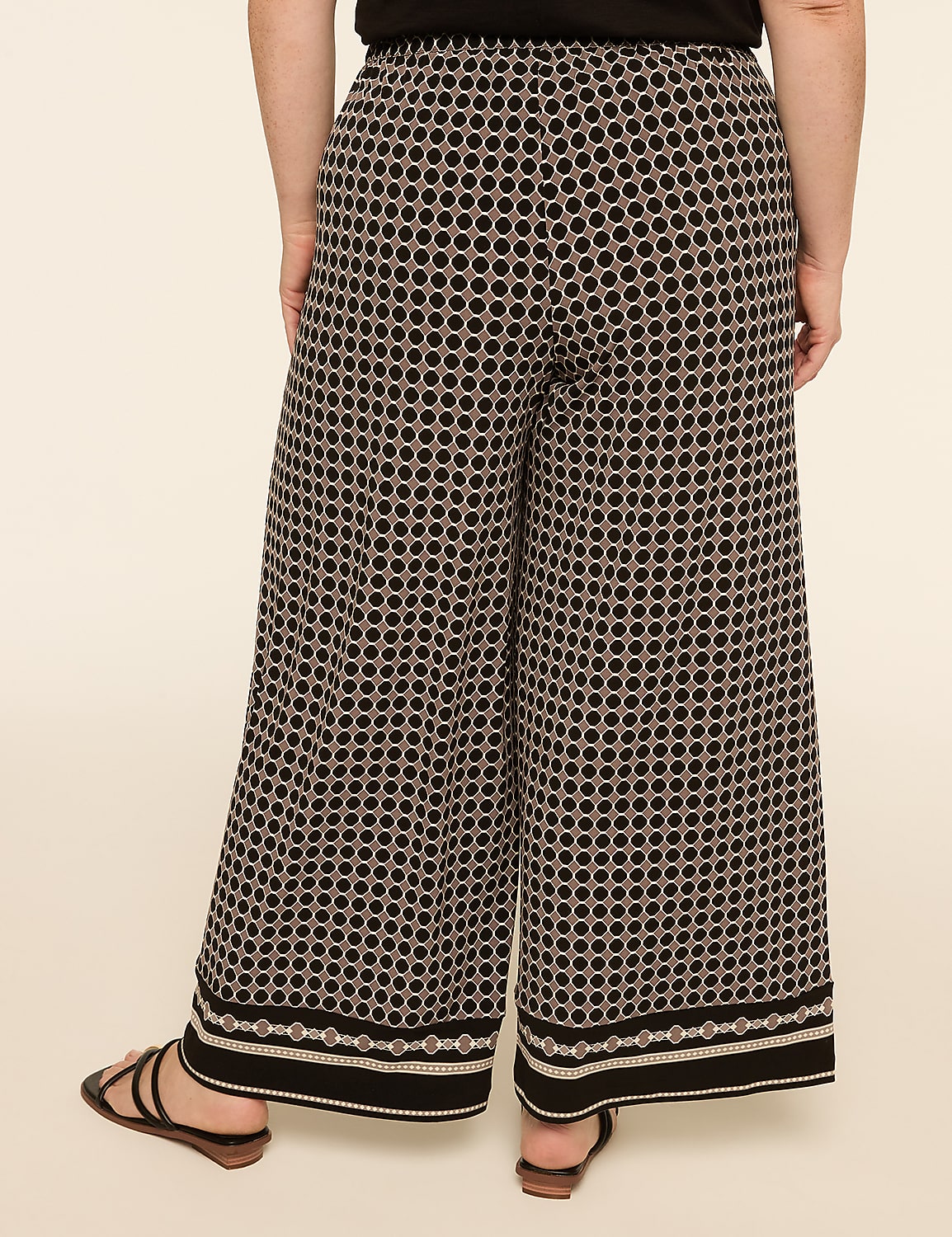 A person stands wearing patterned wide-leg pants and sandals against a plain, light-colored background. Product Image 2
