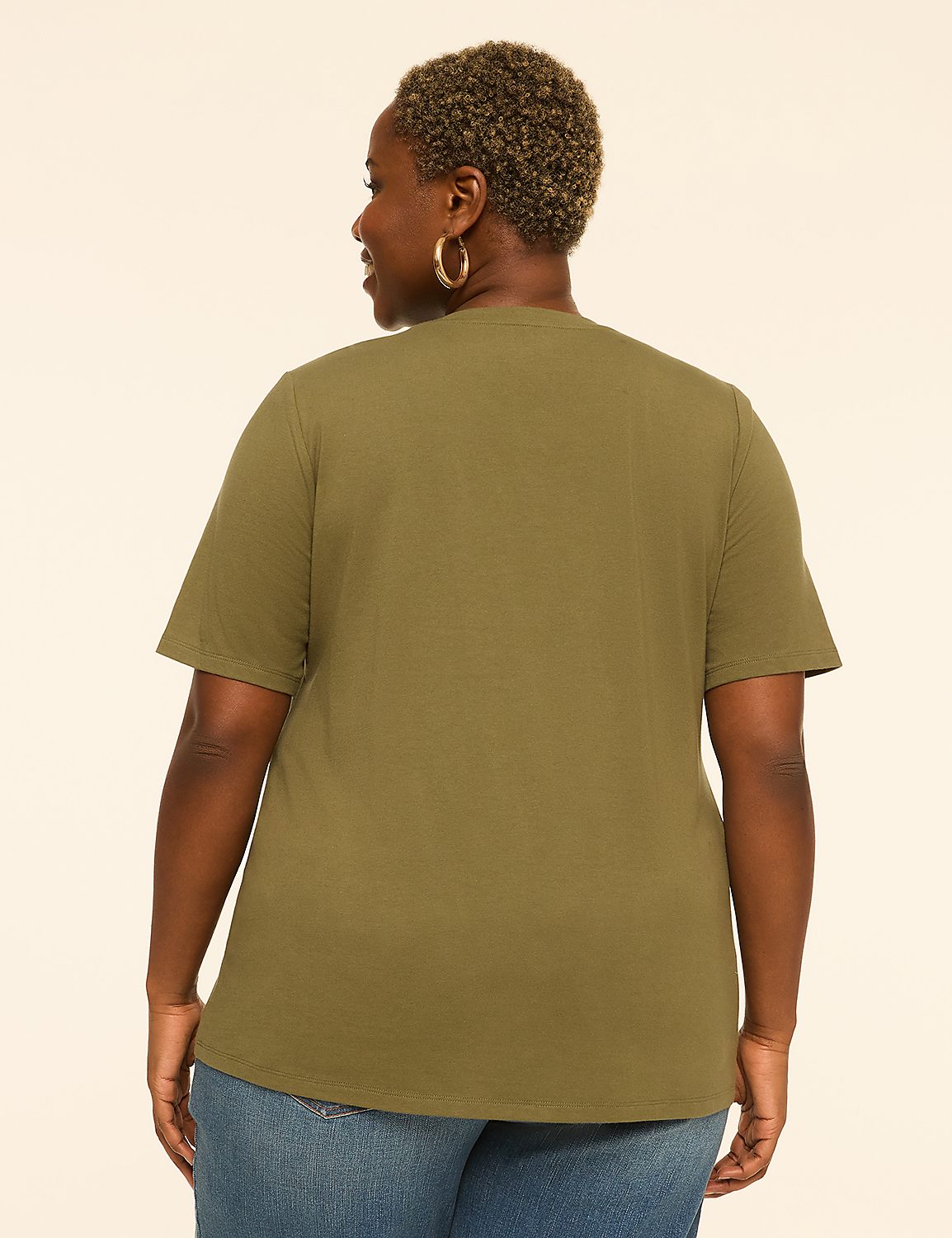 A woman in a green t-shirt and blue jeans stands against a plain, light-colored background. Product Image 2