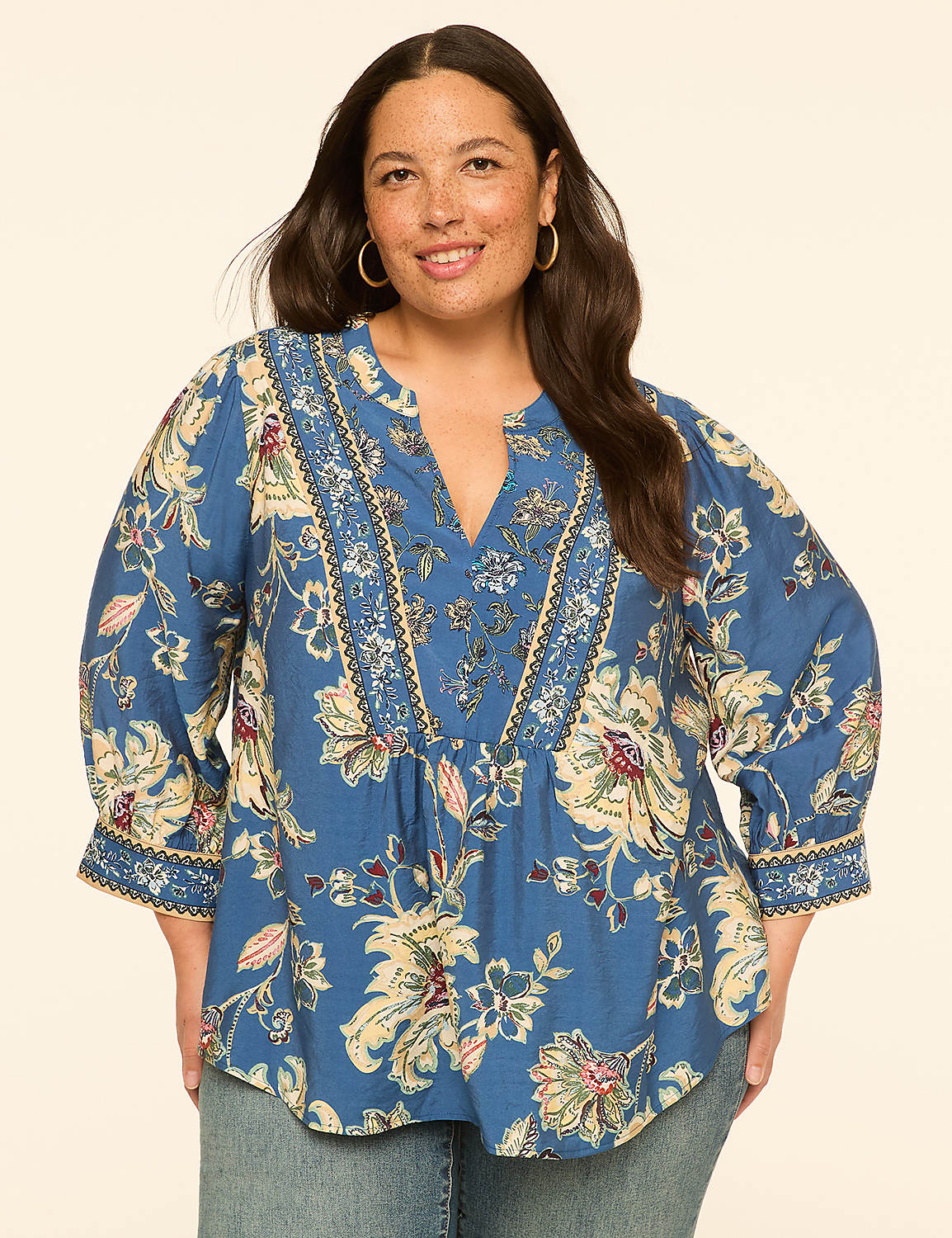 A woman in a blue floral blouse stands against a plain, light-colored background. Product Image 1