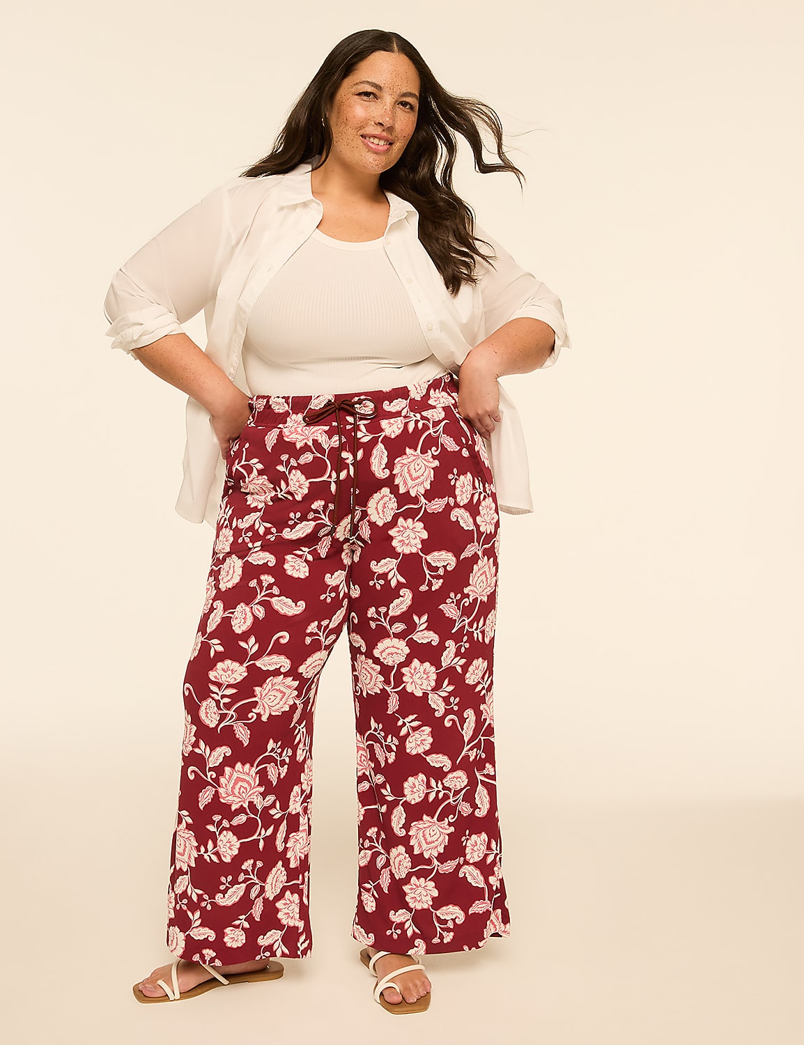 A woman in a white shirt and floral pants stands against a plain, light-colored background. Product Image 3