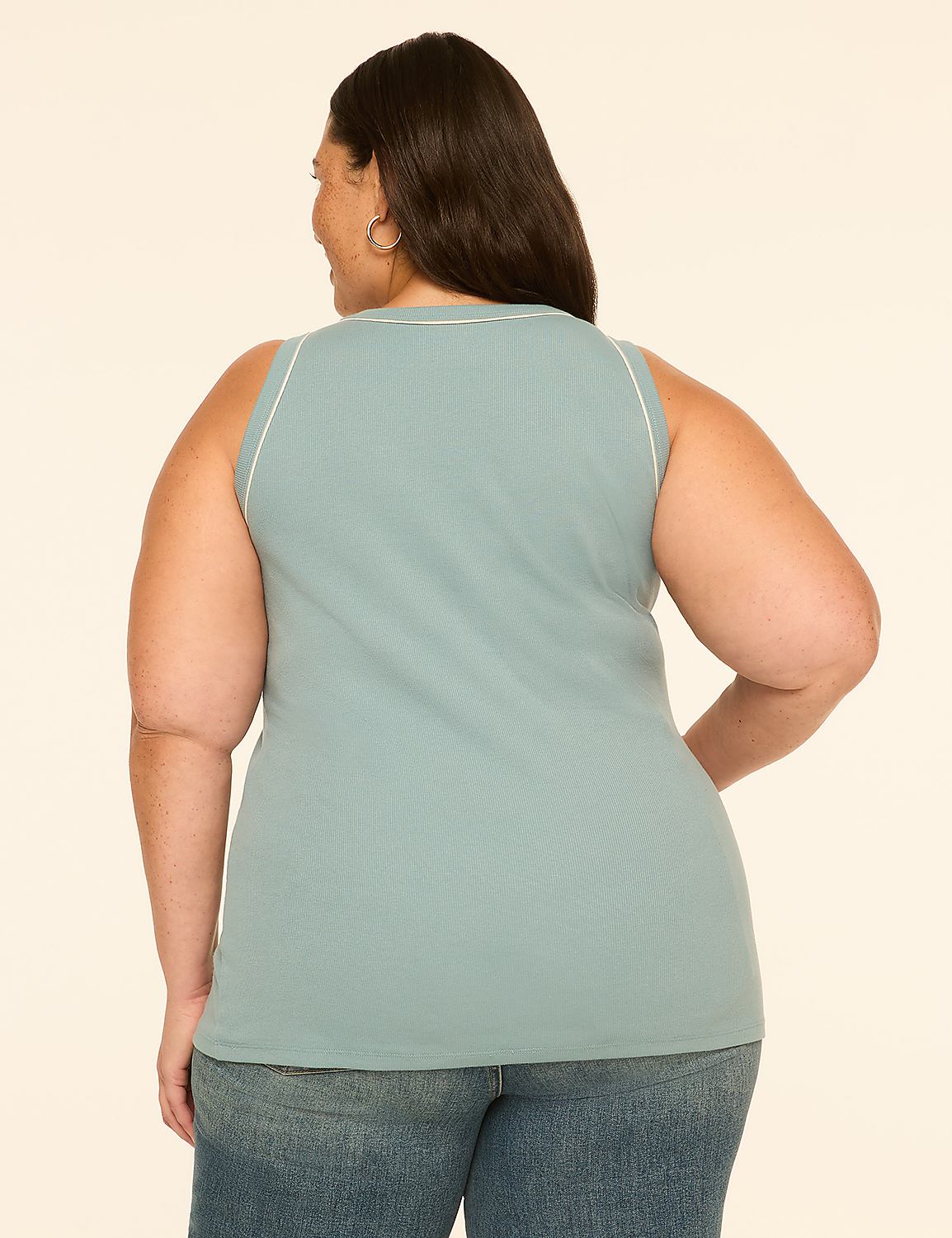A woman in a teal ribbed tank top and blue jeans stands against a plain cream background. Product Image 2