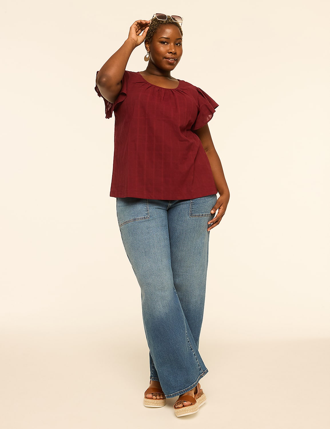 A woman in a maroon top and wide-leg jeans poses against a plain, light-colored background. Product Image 3