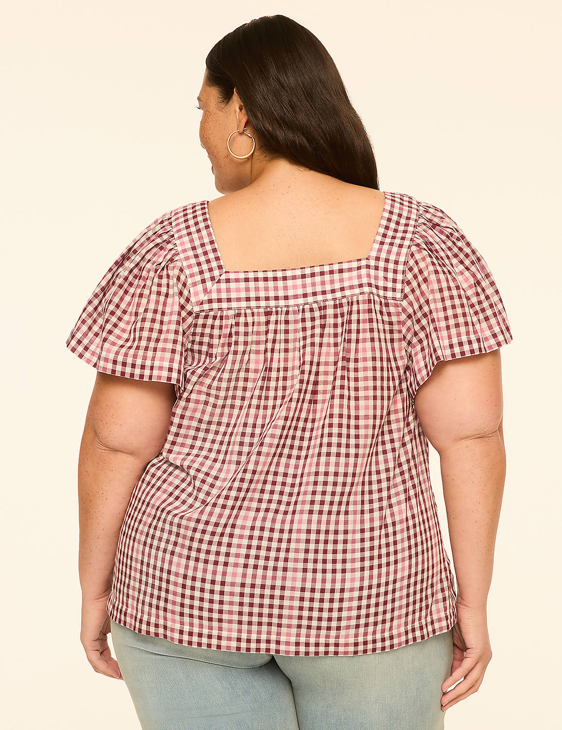 A woman wearing a pink and white gingham top with puffy sleeves stands against a plain beige background. Product Image 2