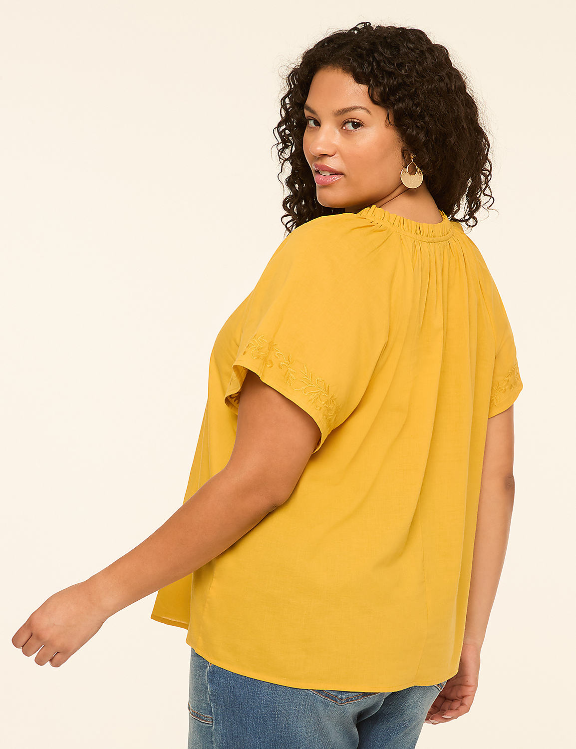 A woman in a yellow top and blue jeans poses against a plain, light-colored background. Product Image 2