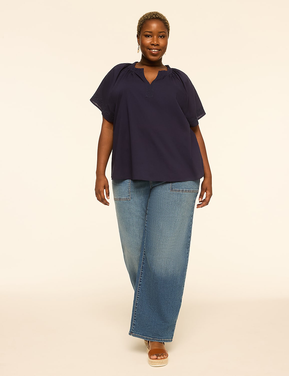 A woman in a navy top and wide-leg jeans stands against a plain, light-colored background. Product Image 3