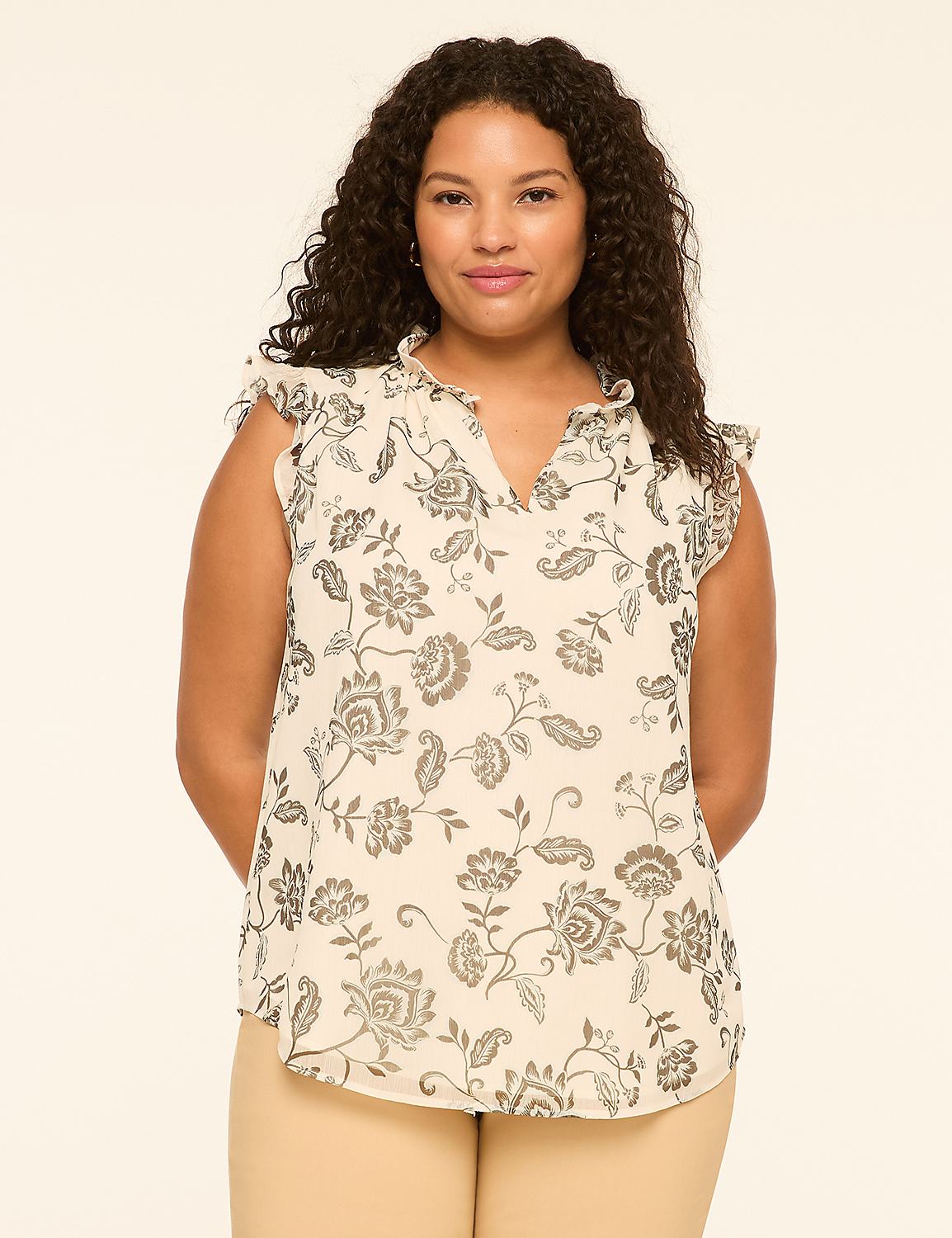 A woman with curly dark hair stands in the foreground against a plain, light-colored background. Product Image 1