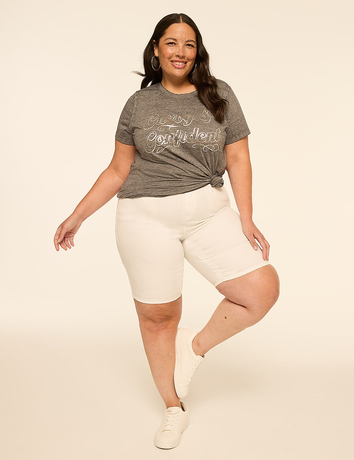 A smiling woman in a grey t-shirt and white shorts stands against a plain, light-colored background. Product Image 3