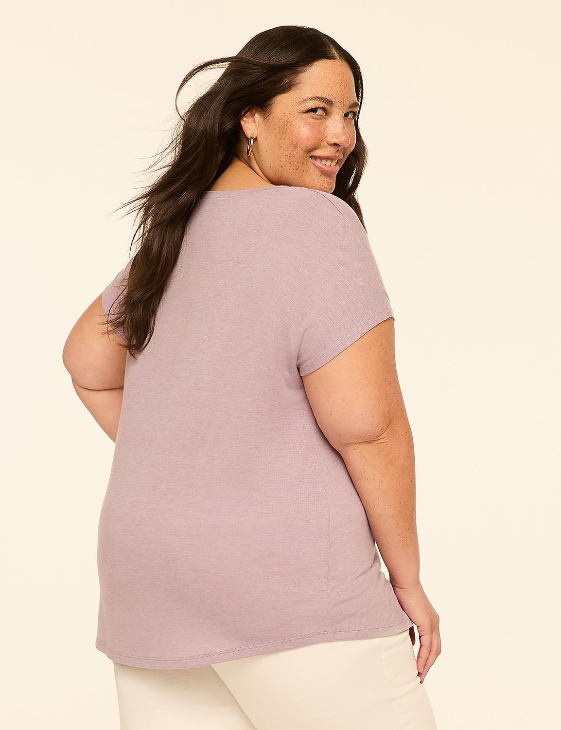 A woman with dark hair and a light purple shirt smiles over her shoulder against a plain, light-colored background. Product Image 2