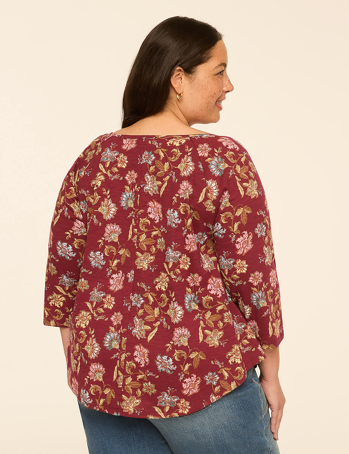 A woman in a floral-patterned maroon top and blue jeans stands against a plain, light-colored background. Product Image 2