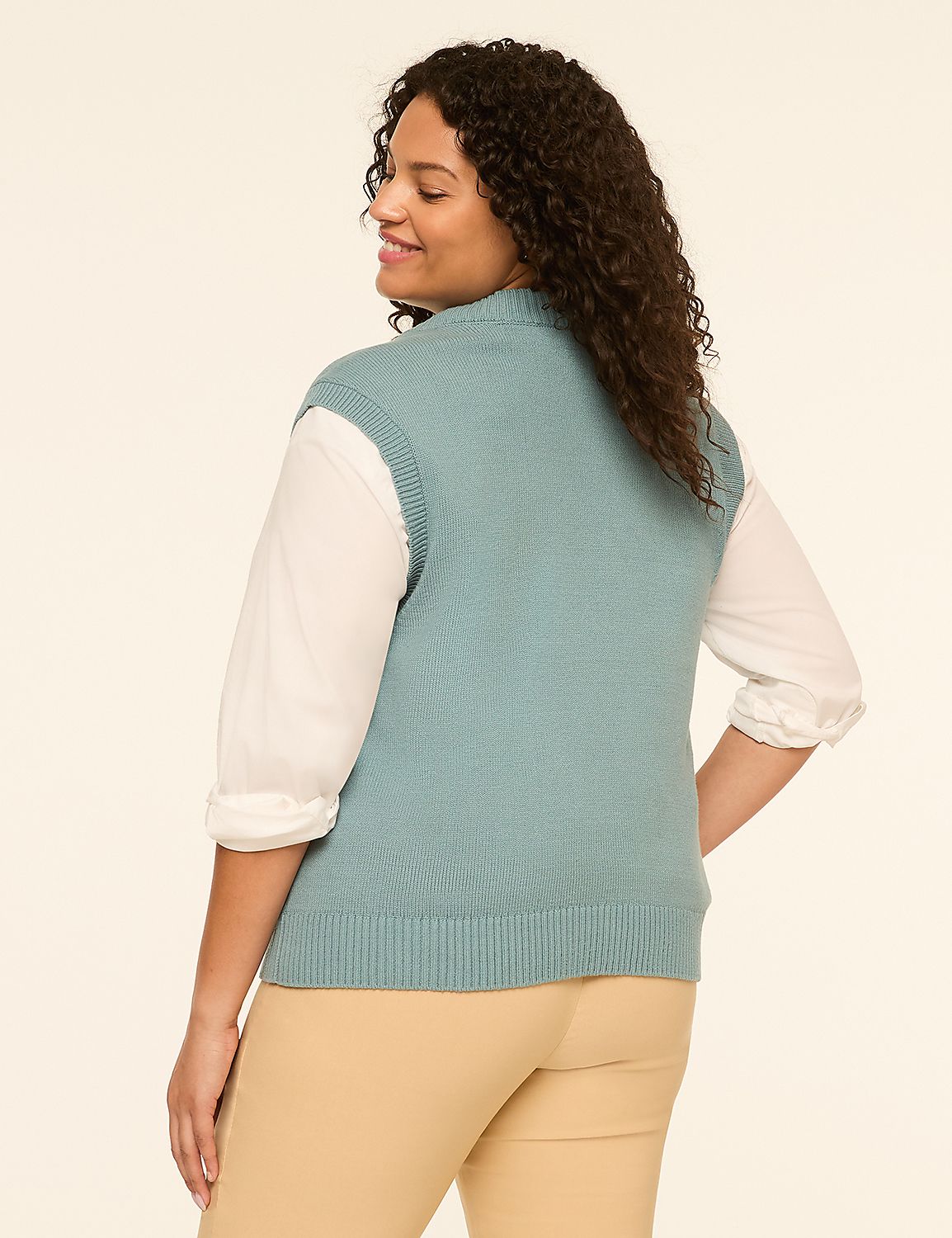 A woman in a teal sweater vest and tan pants stands against a plain, light-colored background. Product Image 2