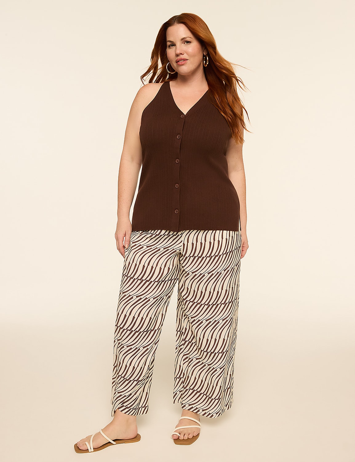 A woman with auburn hair stands in the foreground wearing a brown halter top and patterned pants, against a plain, light-colored background. Product Image 3