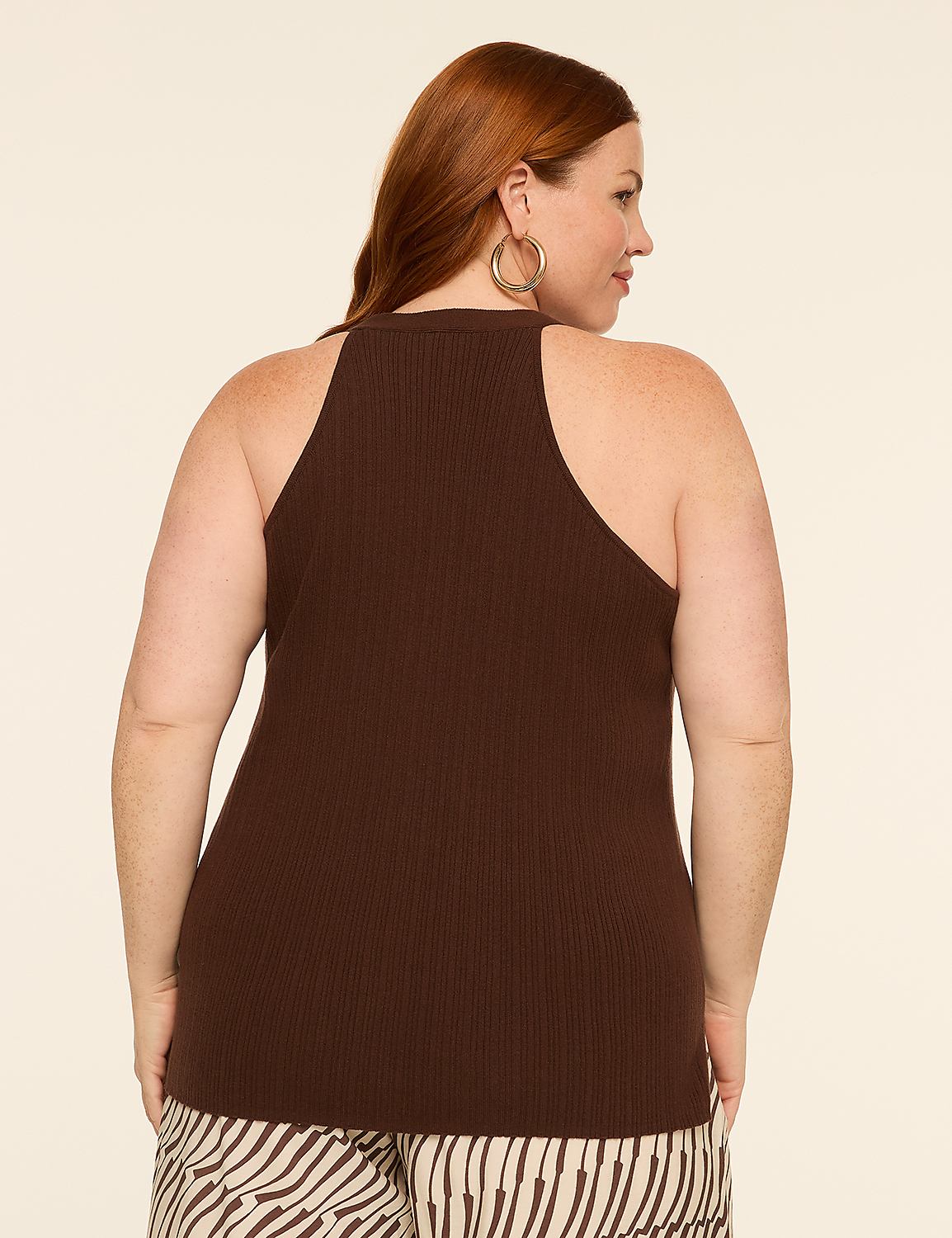 A woman with auburn hair, wearing a brown ribbed tank top and patterned pants, stands against a plain, light-colored background. Product Image 2