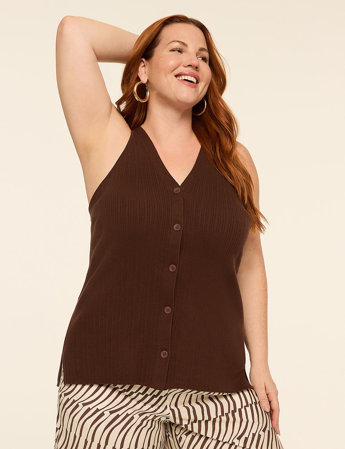 A smiling woman with auburn hair poses in a brown ribbed tank top and patterned pants against a plain cream background. Product Image 1