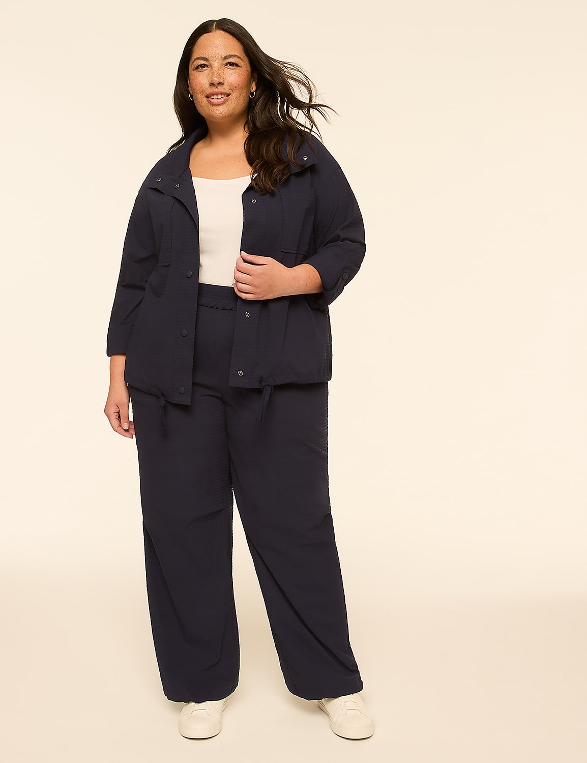A woman in a navy blue jacket and pants stands against a plain, light-colored background. Product Image 3