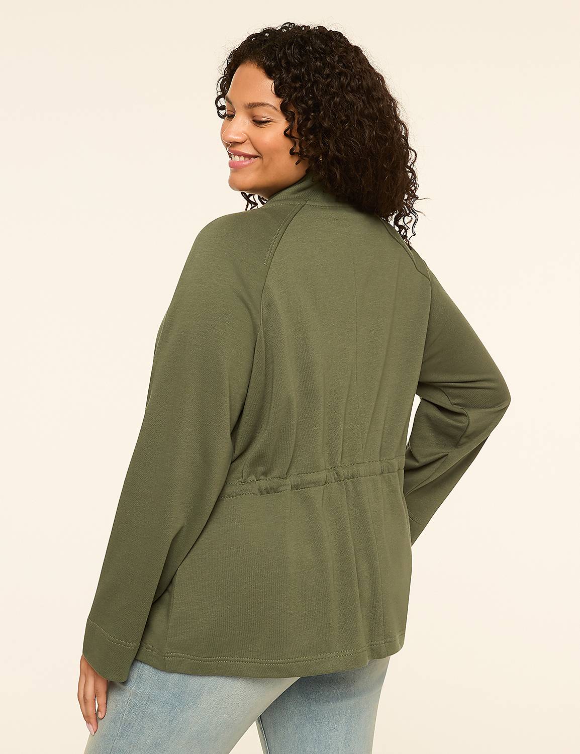 A woman in a green jacket and jeans stands against a plain, light-colored background. Product Image 2