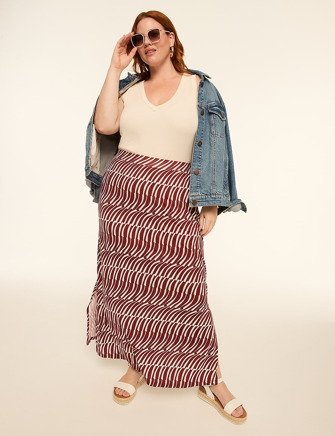 A woman in a patterned skirt and denim jacket poses against a plain, light-colored background. Product Image 3