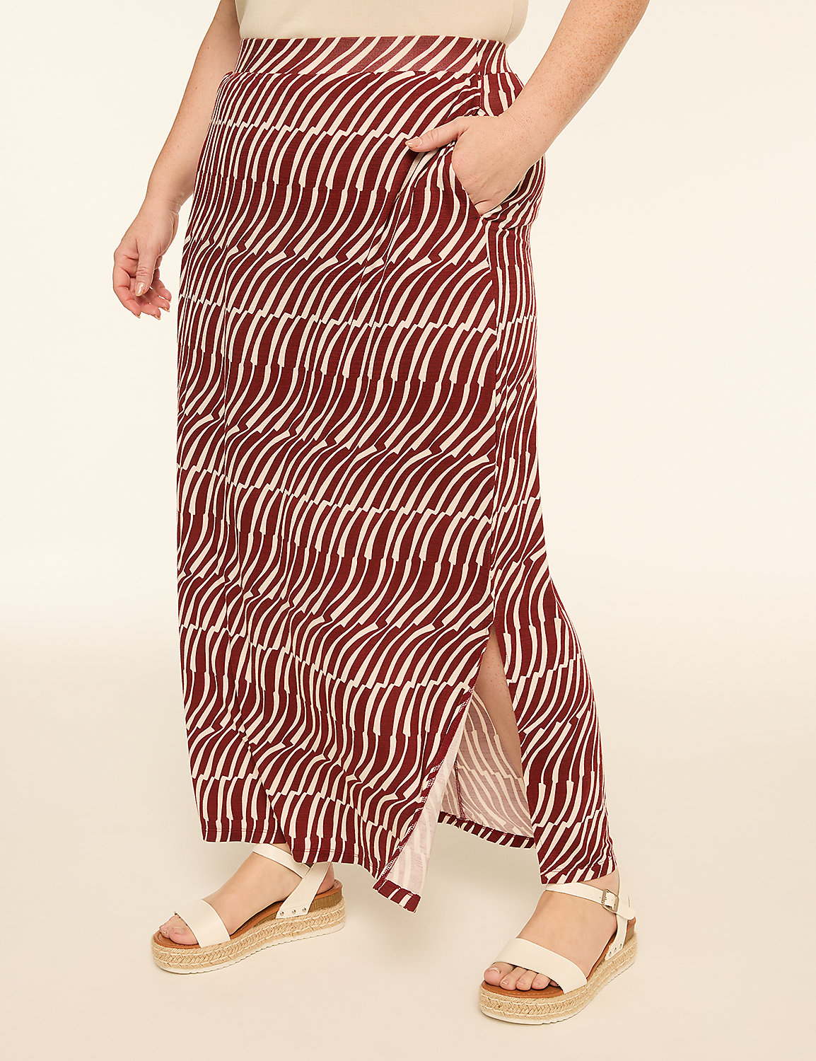 A person wearing a patterned maxi skirt and sandals stands against a plain, light-colored background. Product Image 1
