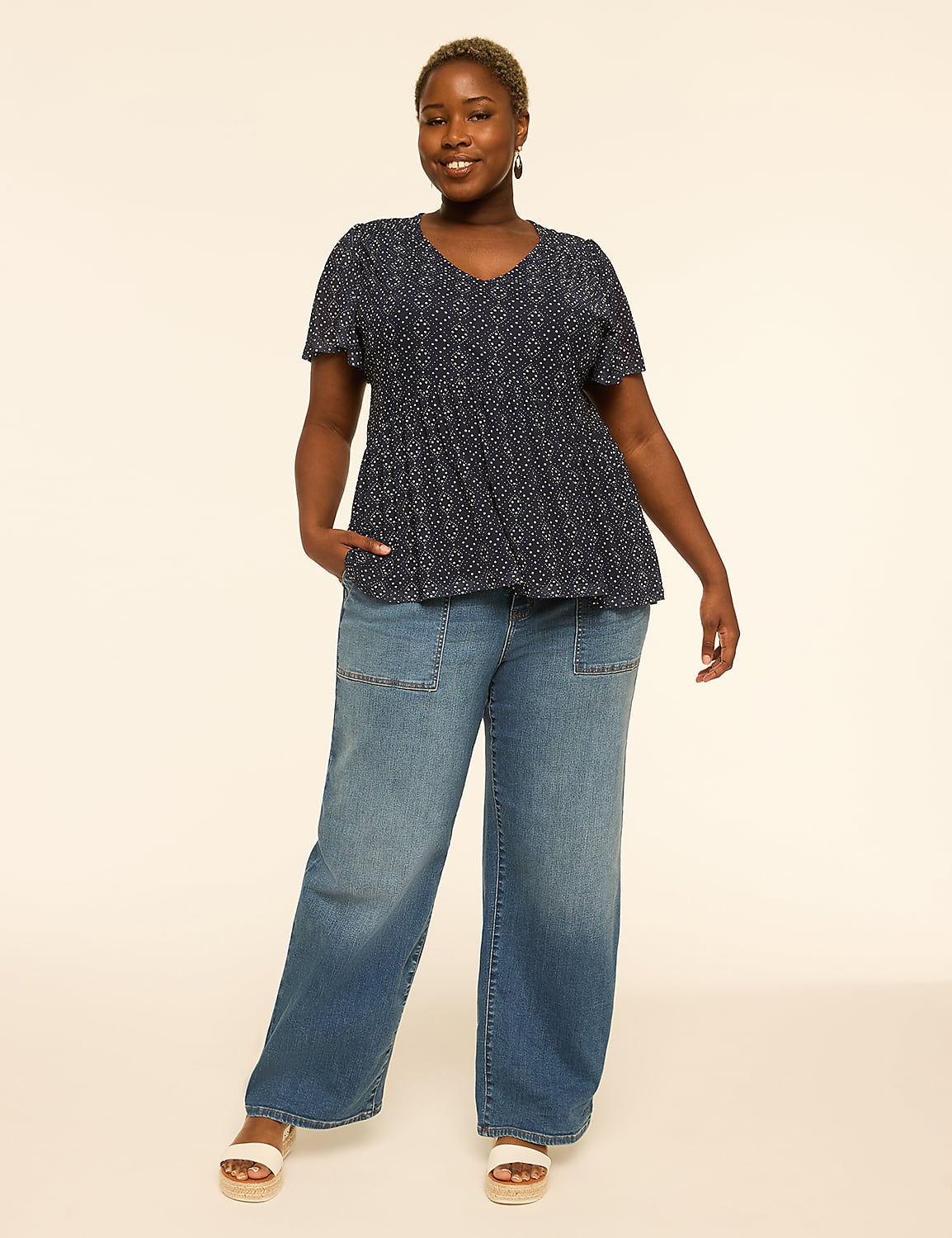 A woman in a patterned blue top and wide-leg jeans stands against a plain, light-colored background. Product Image 3