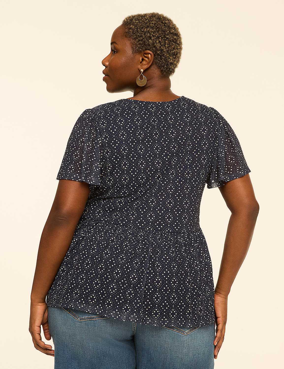 A woman in a patterned navy blouse and jeans stands against a plain, light-colored background. Product Image 2