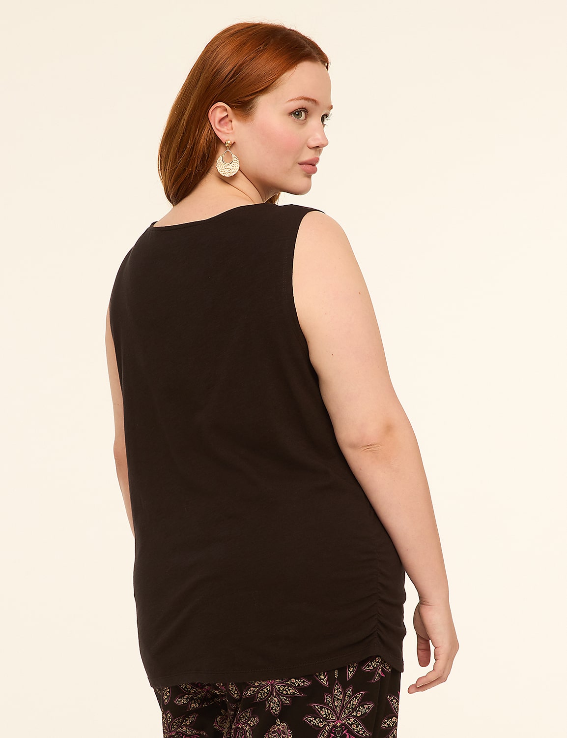 A woman with red hair wearing a black tank top and patterned pants stands against a plain, light-colored background. Product Image 2